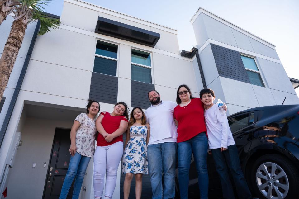 From left, Anaya, 16, Janelliz, 13, Iriana, 17, Nelson Sr., Raysa, and Nelson Torres Jr. pose for a family portrait while standing outside the Torres home in Lake Worth Beach. Thanks to the generosity of Post readers, the Torres family was able to move into a new townhome in December and also go a new car after being featured in the Post's Season to Share series.
