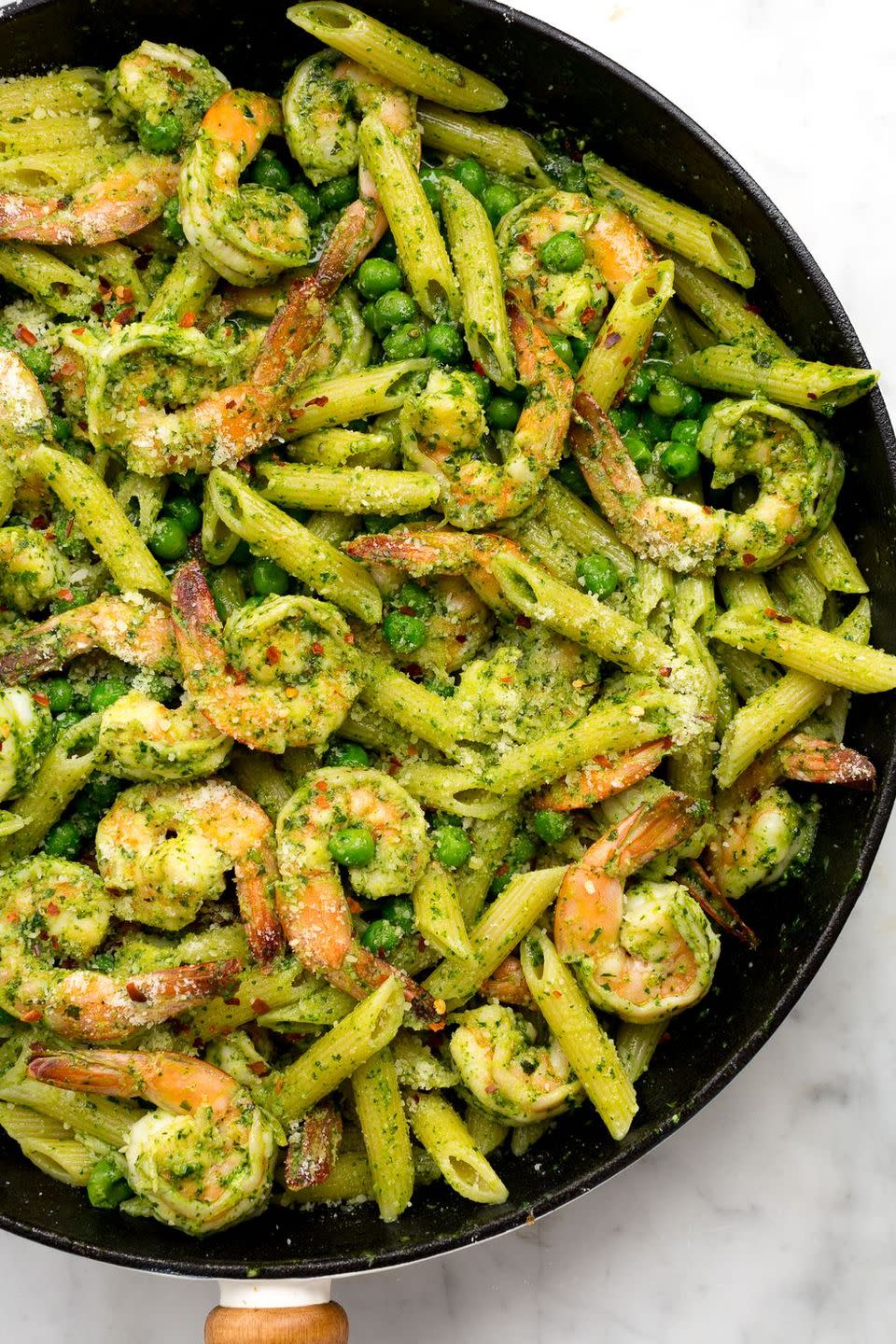 <p>Pesto nuts will love this fresh spring combo of spinach, basil, and sweet peas.</p><p>Get the <a href="https://www.delish.com/uk/cooking/recipes/a35706548/spinach-pesto-penne-with-shrimp-and-peas-recipe/" rel="nofollow noopener" target="_blank" data-ylk="slk:Spinach Pesto Penne with Prawns and Peas;elm:context_link;itc:0;sec:content-canvas" class="link ">Spinach Pesto Penne with Prawns and Peas</a> recipe.</p>