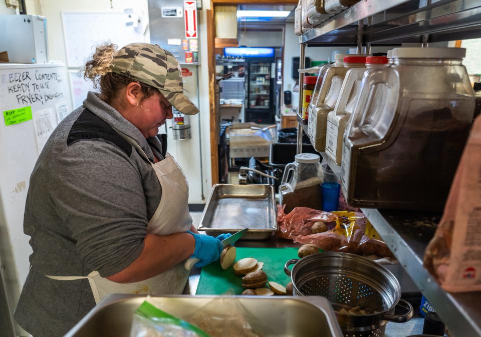 Shannon's Home Cooking owner Shannon Greathouse cuts potatoes in the kitchen of her business in Gwinn on Wednesday, Oct. 20, 2021.“This is like a coping mechanism,” she said. “It’s something do to basically calm my head down. I’m unmedicated, so this is my medication. I’ll even tell people, ‘You can ask me questions, but I’m not going to make eye contact or put a lot of thought into my answers.’ Because this is my quiet time.”