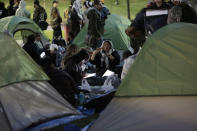 People prepare to camp out for the night during a pro-Palestinian protest at the College Green in the heart of the University of Pennsylvania campus in the in Philadelphia on Thursday, April 25, 2024. (Elizabeth Robertson/The Philadelphia Inquirer via AP)