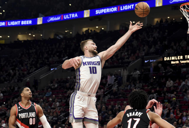 Sacramento Kings forward Domantas Sabonis, center, shoots as Portland Trail Blazers guard Shaq Harrison, left, and Shaedon Sharpe, right, defend during the first half of an NBA basketball game in Portland, Ore., Friday, March 31, 2023. (AP Photo/Steve Dykes)