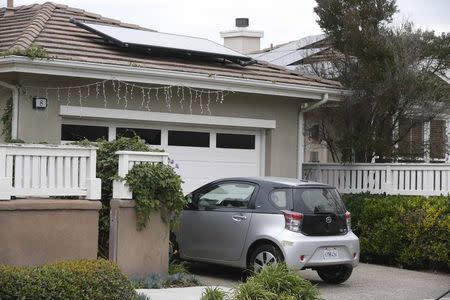 A Scion IQ electric car given to a resident of University of California, Irvine faculty housing is seen parked in front of home with solar panels on the roof in Irvine, California January 26, 2015. REUTERS/Lucy Nicholson