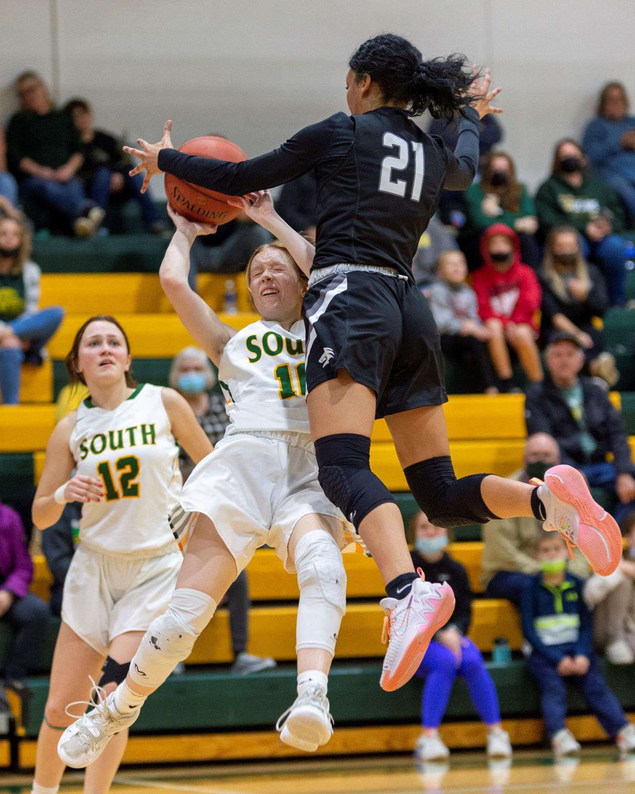 Salina South's Kylie Arnold (10) draws a hard foul from Kara Smith (21) of Campus on Friday night at the South gym.