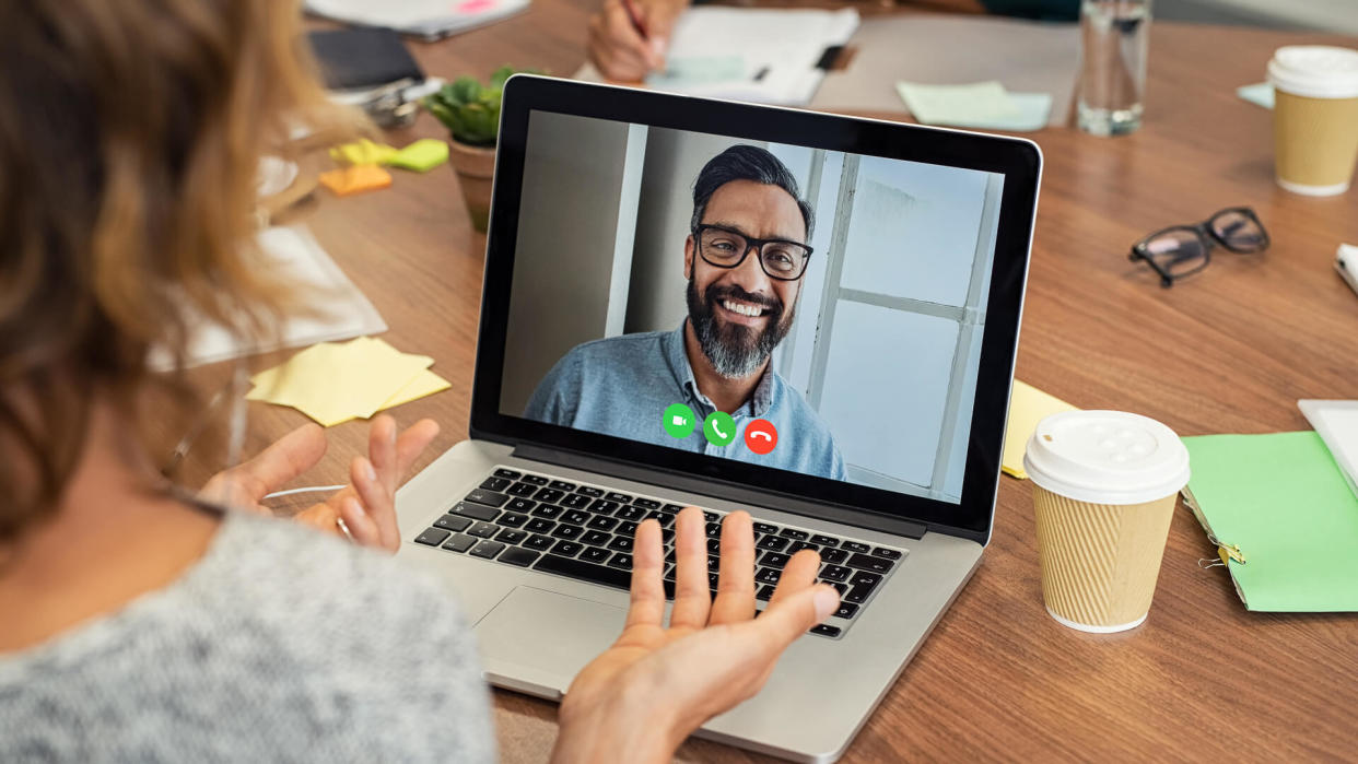 Portrait of smiling man video conferencing on laptop with businesswoman