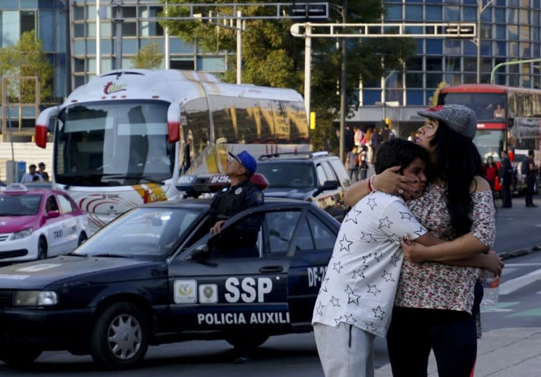 A woman embraces a boy as the powerful earthquake rocked Mexico City, triggering memories of deadly quakes last year