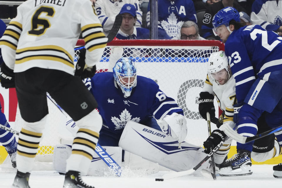 Toronto Maple Leafs goaltender Joseph Woll (60) makes a save as Boston Bruins' Jake DeBrusk (74) and Maple Leafs' Matthew Knies (23) battle during second-period action in Game 6 of an NHL hockey Stanley Cup first-round playoff series in Toronto, Thursday, May 2, 2024. (Nathan Denette/The Canadian Press via AP)