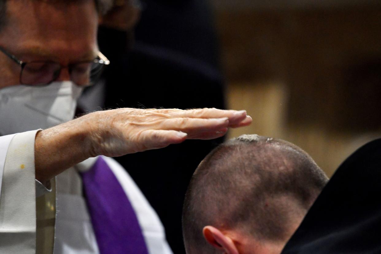 A priest receives ashes on the head during the Ash Wednesday mass which opens Lent, the forty-day period of abstinence and deprivation for Christians before Holy Week and Easter, at the Santa Sabina church in Rome on March 2, 2022.