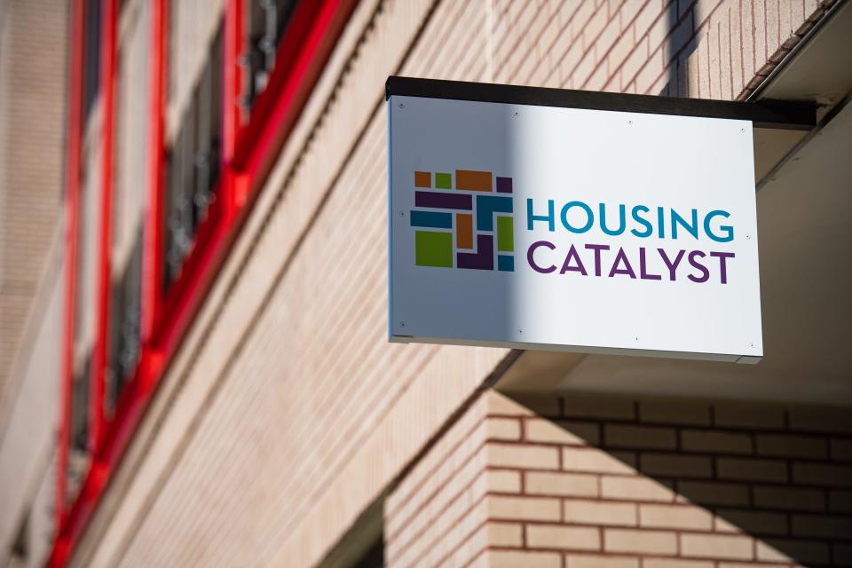 A sign hangs above the soon-to-be Housing Catalyst office on the ground level of Oak 140, a recently constructed apartment building at 140 E. Oak St., on Jan. 26 in downtown Fort Collins.