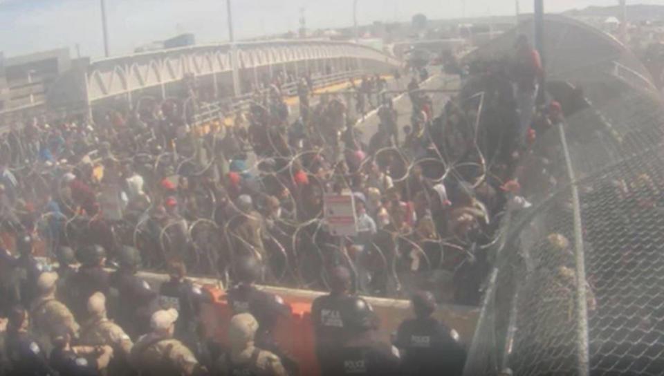 U.S. Customs and Border Protection officials, Border Patrol Agents, and El Paso Police are seen, lower left, on the Texas side of the Paso Del Norte International Bridge which links El Paso to Juarez, Mexico, via a border crossing, as migrants gather on the other side, March 12, 2023. / Credit: City of El Paso/Handout