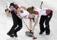 Canada's second Jill Officer (back L) watches as vice Kaitlyn Lawes and lead Dawn McEwen (R) sweep ahead of a stone during their women's curling round robin game against the U.S. in the Ice Cube Curling Centre at the Sochi 2014 Winter Olympic Games February 16, 2014. REUTERS/Ints Kalnins (RUSSIA - Tags: SPORT OLYMPICS SPORT CURLING)