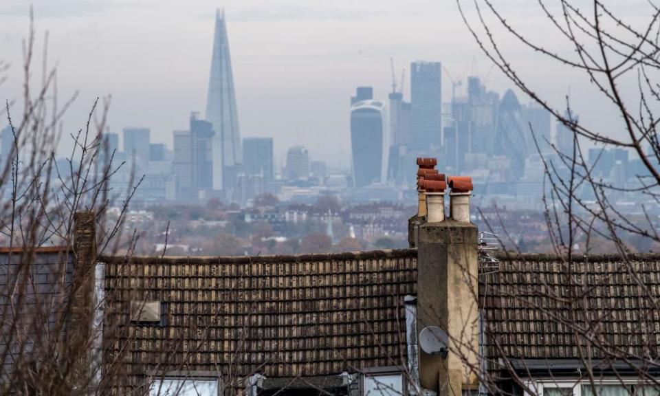 Skyscrapers on the horizon beyond the rooftops of residential houses in London.