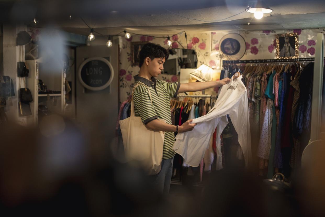 Student shopping in a vintage clothing store looking at one of the shop products in the North East of England.