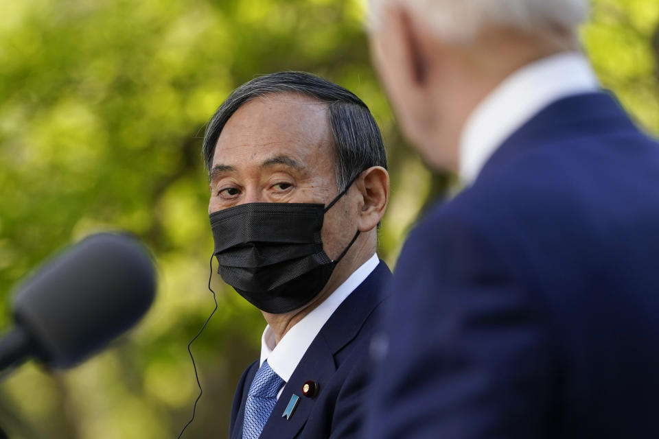 Japanese Prime Minister Yoshihide Suga, listens as President Joe Biden speaks at a news conference in the Rose Garden of the White House, Friday, April 16, 2021, in Washington. (AP Photo/Andrew Harnik)