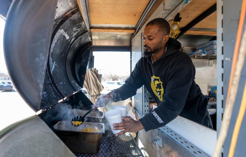 Timmy Campbell, aka Cornman, scoops up corn he’ll make into the Mexican dish eloté, on Thursday, March 2, 2023, in the Fall Creek Place neighborhood of Indianapolis. 