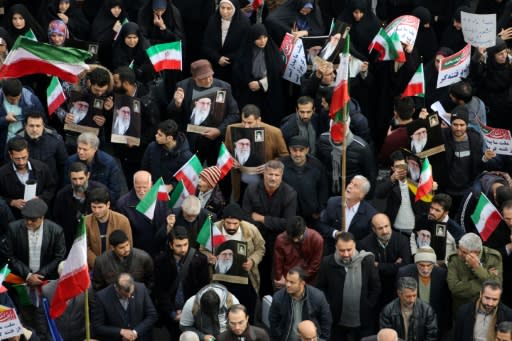 Iranian pro-government demonstrators raise national flags and pictures of the Islamic republic's supreme leader, Ayatollah Ali Khamenei