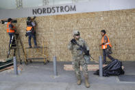 A member of the National Guard stands in front of a Nordstrom store as it is boarded up Monday, June 1, 2020, in Santa Monica, Calif., a day after unrest and protests over the death of George Floyd, a black man who died in police custody in Minneapolis on May 25. (AP Photo/Marcio Jose Sanchez)