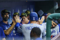 Los Angeles Dodgers' Freddie Freeman, center, returns to the dugout after scoring against the Philadelphia Phillies during the first inning of a baseball game Friday, May 20, 2022, in Philadelphia. (AP Photo/Chris Szagola)