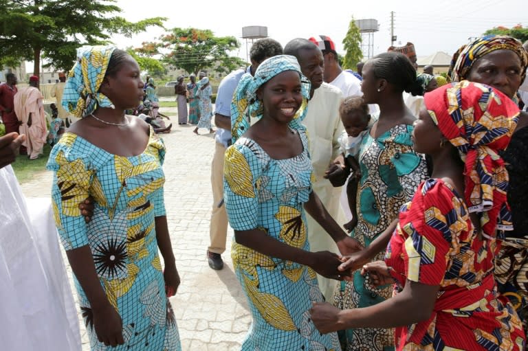 This handout picture released on May 20, 2017 by PGDBA & HND Mass Communication shows family members neing reunited with the released Chibok girls on May 20, 2017, in Abuja