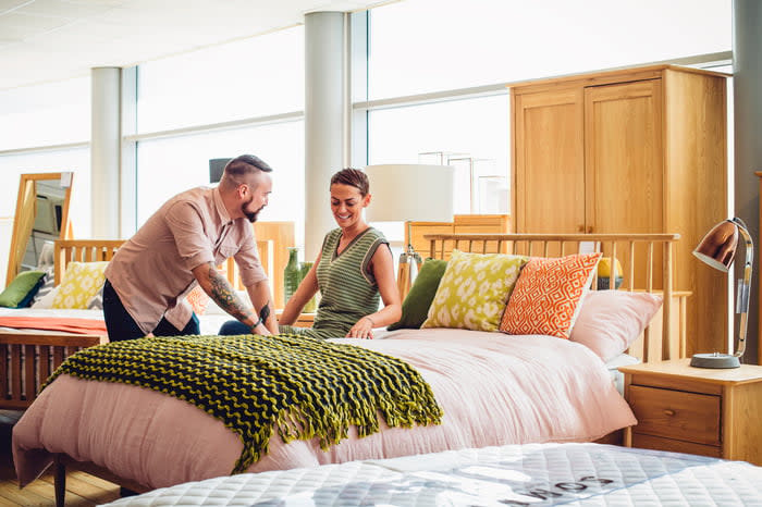 Two people looking at a bed in a store.