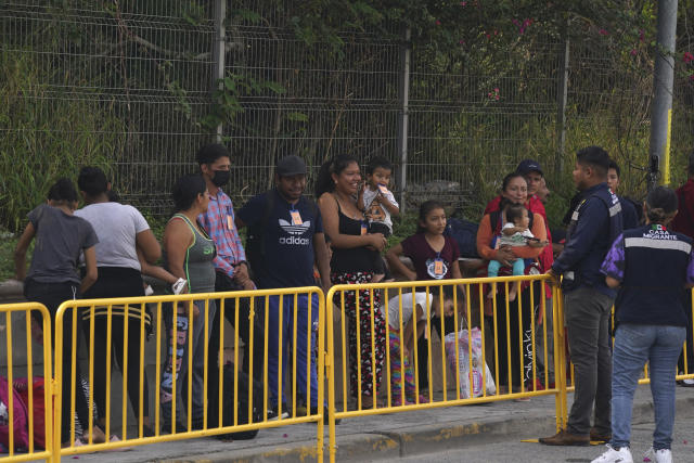 A group of 50 migrants wait outside a Mexican immigration office as they are organized by the Casa Migrante organization to cross the US-Mexico border from Matamoros, Mexico, over the Puerto Nuevo bridge by foot and be processed by U.S. immigration officials, early Friday, May 12, 2023, the day after pandemic-related asylum restrictions called Title 42 were lifted. According to Mexican immigration officials, migrants will be organized to cross in groups of 50. (AP Photo/Fernando Llano)
