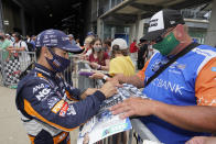 Takuma Sato, of Japan, signs an autograph for a fan during qualifications for the Indianapolis 500 auto race at Indianapolis Motor Speedway, Saturday, May 22, 2021, in Indianapolis. (AP Photo/Darron Cummings)