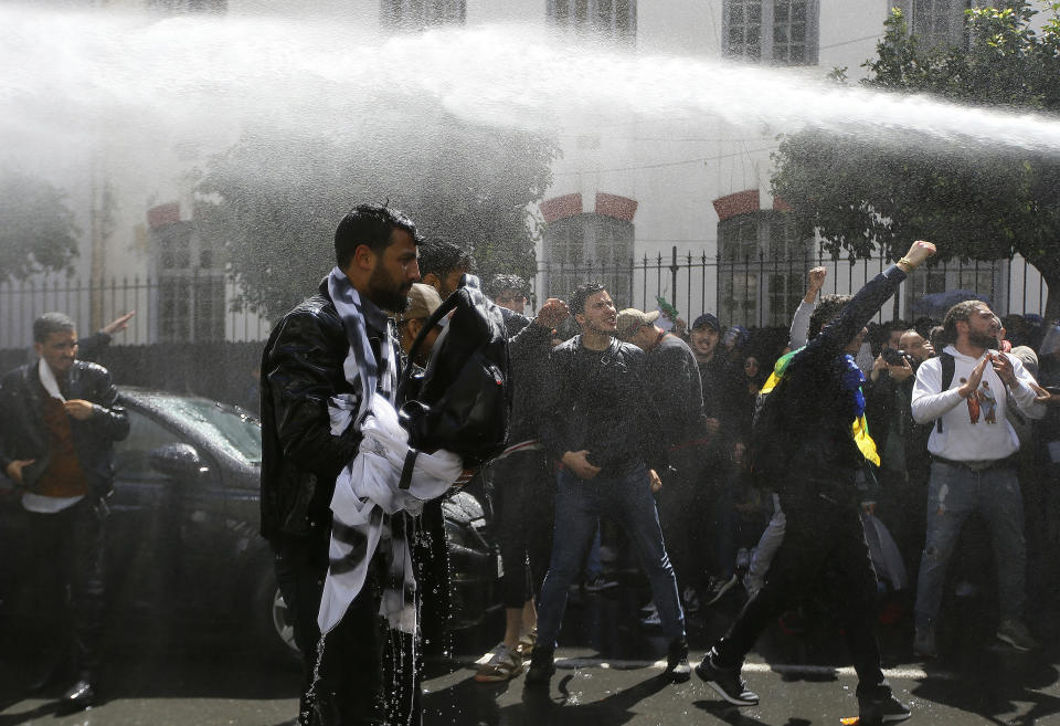 Algerian police forces use a water cannon as students demonstrate in Algiers, Tuesday, April 9, 2019. Algerian police have fired tear gas and water cannon to break up a group of students protesting in the country's capital, less than an hour after the country's parliament chose an interim leader. (AP Photo/Anis Belghoul)