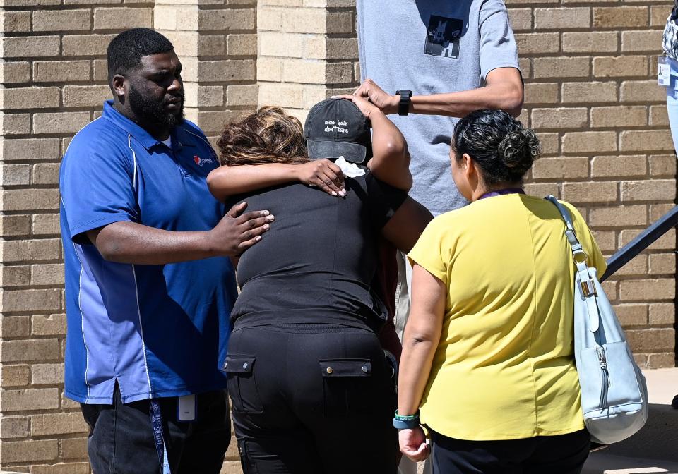 Parents comfort each other as they wait outside the Woodmont Baptist Church for students from Covenant School to arrive after a mass shooting at the school Monday, March 27, 2023, in Nashville, Tenn.