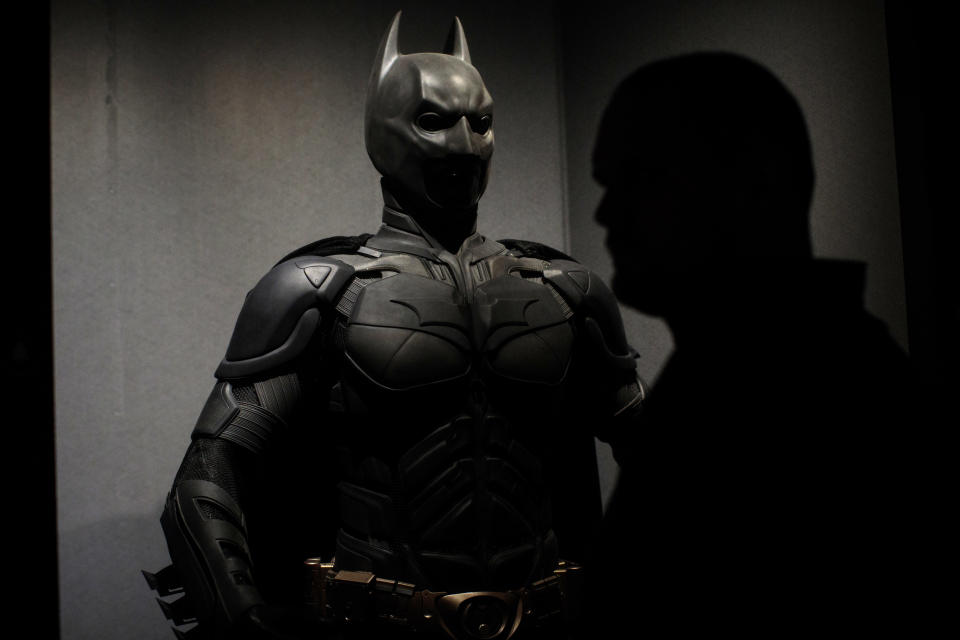 LONDON, ENGLAND - FEBRUARY 22: A visitor walks past a Batman costume from the 2012 Dark Knight Rises film worn by Christian Bale and designed by Lindy Hemming is on display at the DC Comics Exhibition: Dawn Of Super Heroes at the O2 Arena on February 22, 2018 in London, England. The exhibition, which opens on February 23rd, features 45 original costumes, models and props used in DC Comics productions including the Batman, Wonder Woman and Superman films. (Photo by Jack Taylor/Getty Images)
