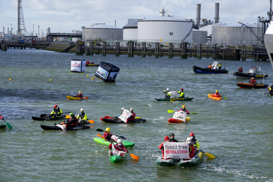 Greenpeace climate activists paddle ashore after Dutch police broke up a protest at a Shell refinery in Rotterdam, Netherlands, Monday, Oct. 4, 2021. A coalition of environmental groups launched a campaign calling for a Europe-wide ban on fossil fuel advertising ahead of the United Nations Climate Change Conference, also known as COP26, which start in Glasgow on Oct. 31st, 2021. (AP Photo/Peter Dejong)