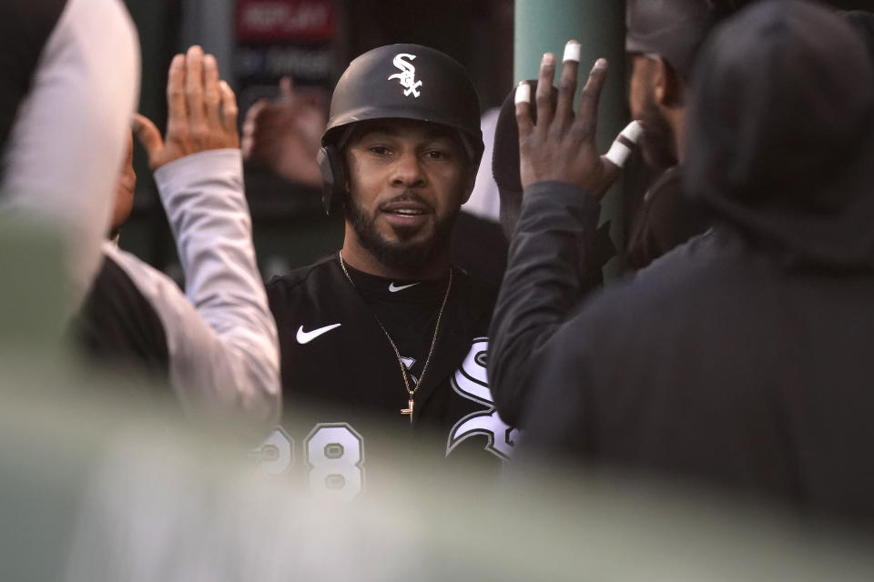 Chicago White Sox's Leury Garcia, center, is welcomed into the dugout after scoring on a sacrifice fly by Nick Madrigal in the sixth inning of a baseball game against the Boston Red Sox, Sunday, April 18, 2021, in Boston. The game is the second of a doubleheader Sunday. (AP Photo/Steven Senne)