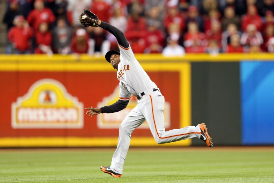 Joaquin Arias #13 of the San Francisco Giants catches a fly ball by Jay Bruce #32 of the Cincinnati Reds in the eighth inning in Game Three of the National League Division Series at the Great American Ball Park on October 9, 2012 in Cincinnati, Ohio. (Photo by Andy Lyons/Getty Images)