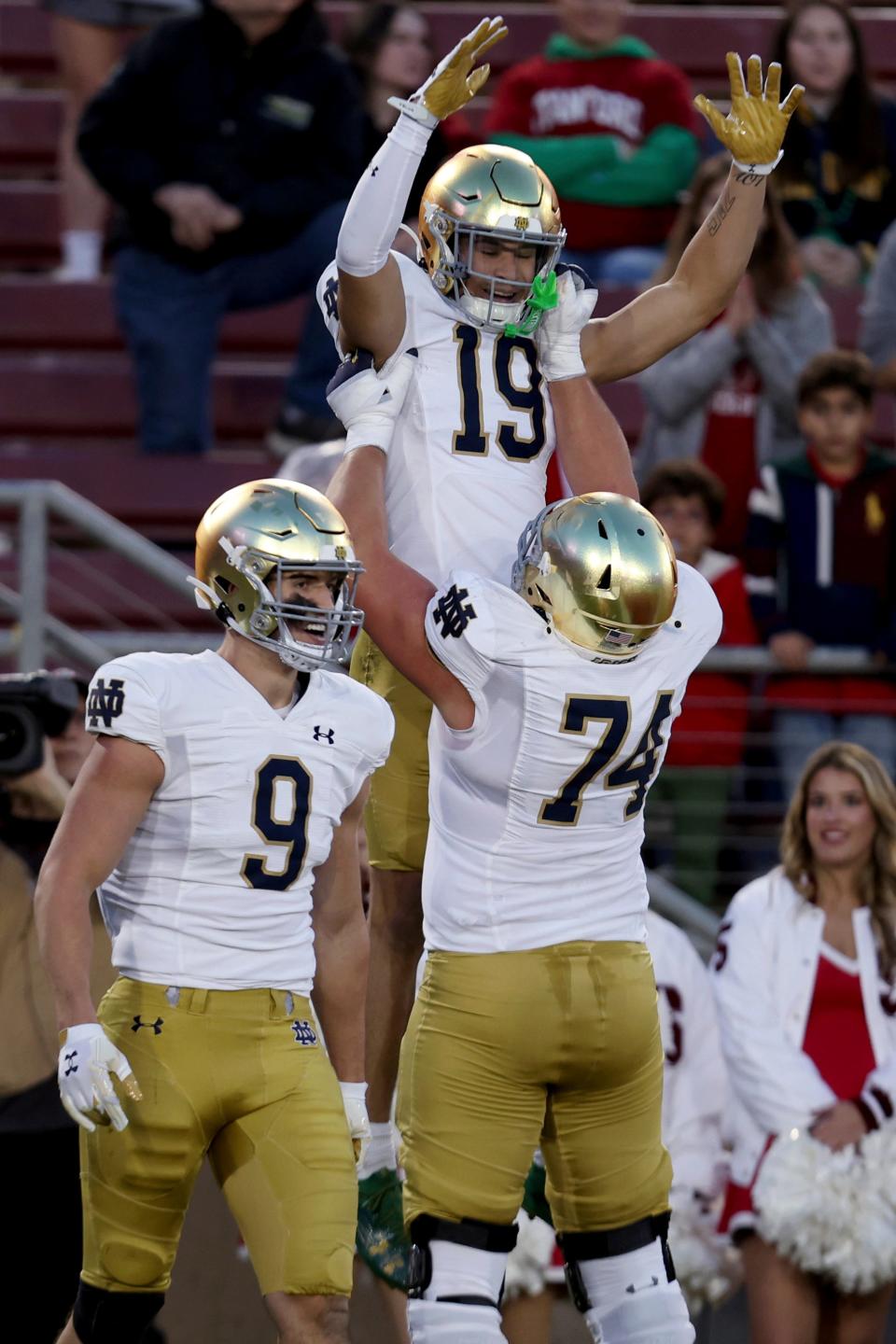 Notre Dame wide receiver Jaden Greathouse (19) celebrates with offensive lineman Billy Schrauth (74) and tight end Eli Raridon (9) after scoring a touchdown against Stanford during the first half of an NCAA college football game in Stanford, Calif., Saturday, Nov. 25, 2023. (AP Photo/Jed Jacobsohn)