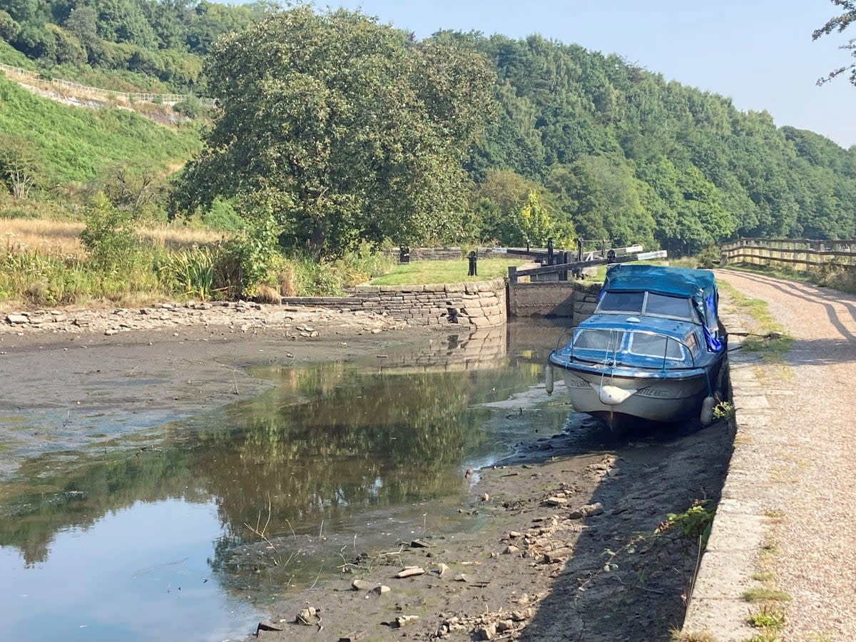 A boat lies in the dried up Huddersfield narrow canal near Linthwaite (Ashley Broadley/PA) (PA Wire)