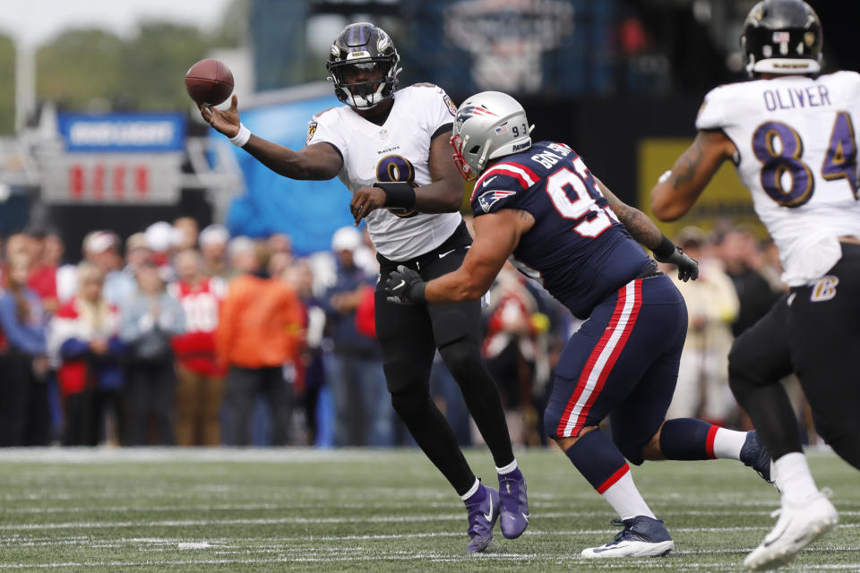 Baltimore Ravens quarterback Lamar Jackson (8) passes under pressure from New England Patriots defensive end Lawrence Guy (93) in the first half of an NFL football game, Sunday, Sept. 25, 2022, in Foxborough, Mass. (AP Photo/Paul Connors)