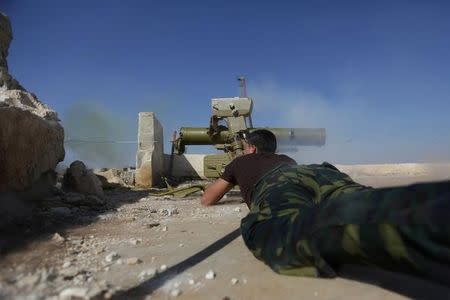 A rebel fighter in Marea city shoots a weapon towards Syria Democratic Forces (SDF) controlled Tell Rifaat town, northern Aleppo province, Syria October 21, 2016. REUTERS/Khalil Ashawi