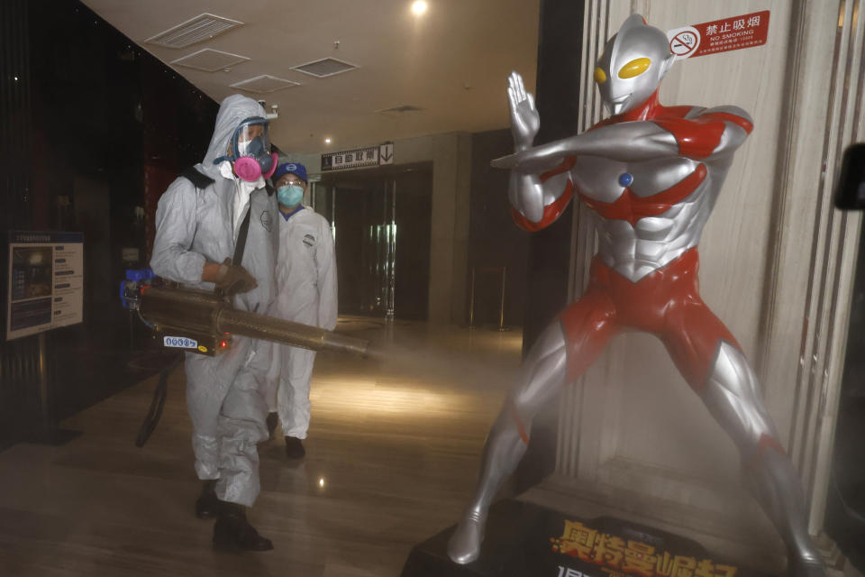 Volunteers with the Blue Sky Rescue team perform disinfecting of a cinema before it reopens for business in Beijing Friday, July 24, 2020. Theaters in China, the world's second largest movie market, this week reopened from the coronavirus shut down with theaters limited to 30% capacity. (AP Photo/Ng Han Guan)