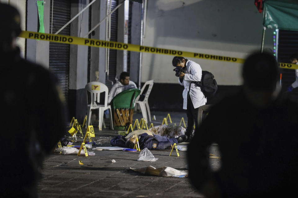 Forensic investigators document the crime scene where authorities say at least four people have been killed and nine wounded in a shooting at Garibaldi Plaza, in Mexico City, Friday, Sept. 14, 2018. Gunmen dressed as mariachis opened fired on an establishment in the capital’s emblematic plaza, a spot popular for tourists. (AP Photo/Stringer)