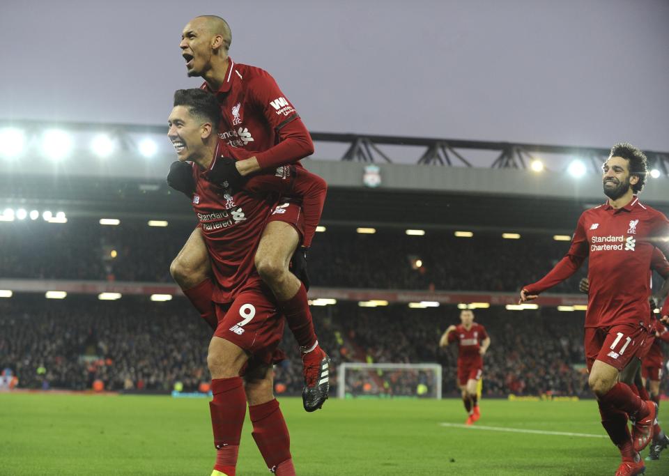 Liverpool's Roberto Firmino, left, celebrates with his teammate Liverpool's Fabinho, top, and Liverpool's Mohamed Salah, right, after scoring his side's second goal during the English Premier League soccer match between Liverpool and Crystal Palace at Anfield in Liverpool, England, Saturday, Jan. 19, 2019. (AP Photo/Rui Vieira)