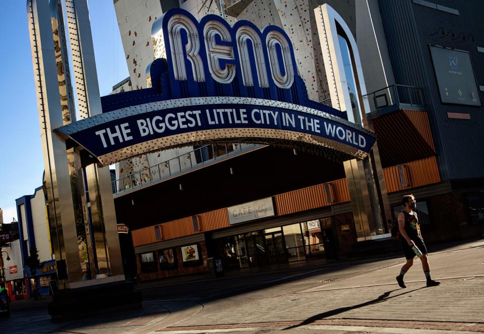 A pedestrian passes by The Reno Arch