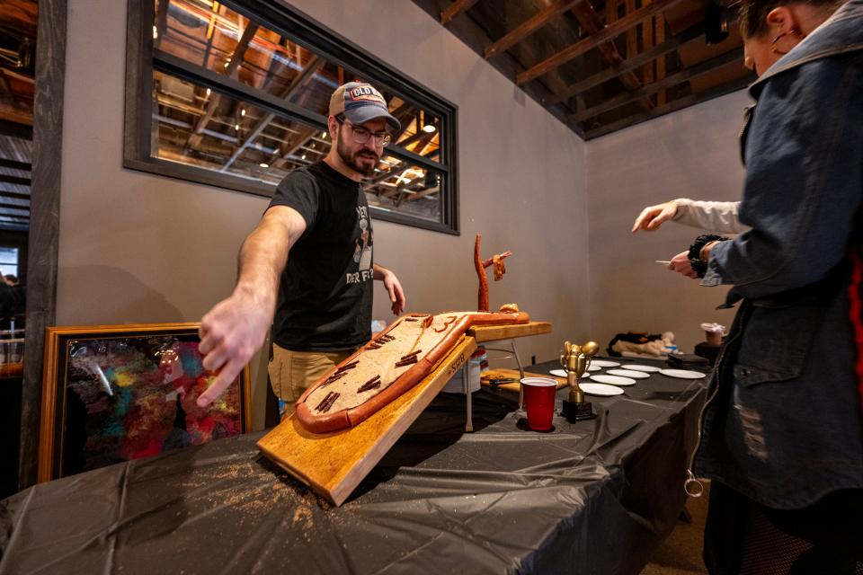 Steven Amore, right, talks with a guest about his “Salvado ‘Deli’” cake during the annual Meat Cake Invitational, Sunday, Feb. 25, 2024, at Half Liter Beer & BBQ Hall, in Indianapolis.