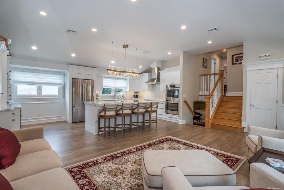 The open floor plan with a kitchen, family room down the steps, and a bedroom up the stairs