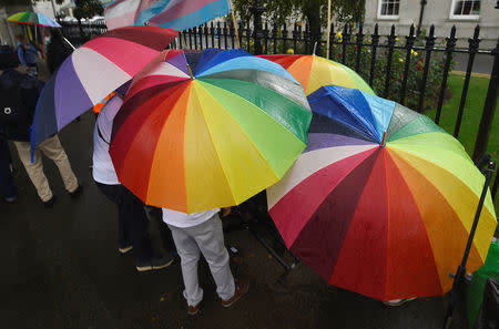 LGBTI protesters shelter under umbrellas during a demonstration outside the Pastoral Congress at the World Meeting of Families in Dublin, Ireland August 23, 2018. REUTERS/Clodagh Kilcoyne