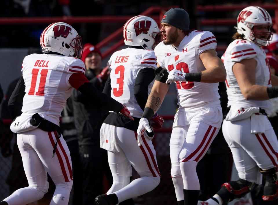 Wisconsin's Nick Herbig, who had been ejected for targeting on a hit on Nebraska quarterback Casey Thompson, celebrates a touchdown with Skyler Bell, drawing a penalty for going onto the field without a helmet.