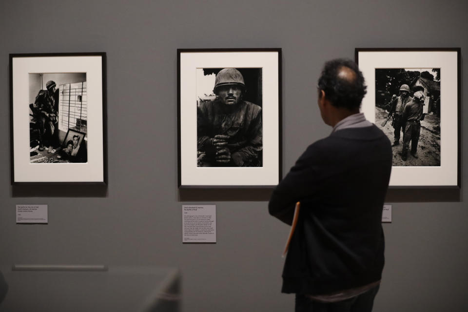 British conflict photographer Don McCullin's photograph, center, of a shell-shocked U.S. marine from the Battle of Hue from the Vietnam War in 1968 is displayed at the launch of his retrospective exhibition at the Tate Britain gallery in London, Monday, Feb. 4, 2019. The exhibition includes over 250 of his black and white photographs, including conflict images from the Vietnam war, Northern Ireland, Cyprus, Lebanon and Biafra, alongside landscape and still life images. (AP Photo/Matt Dunham)