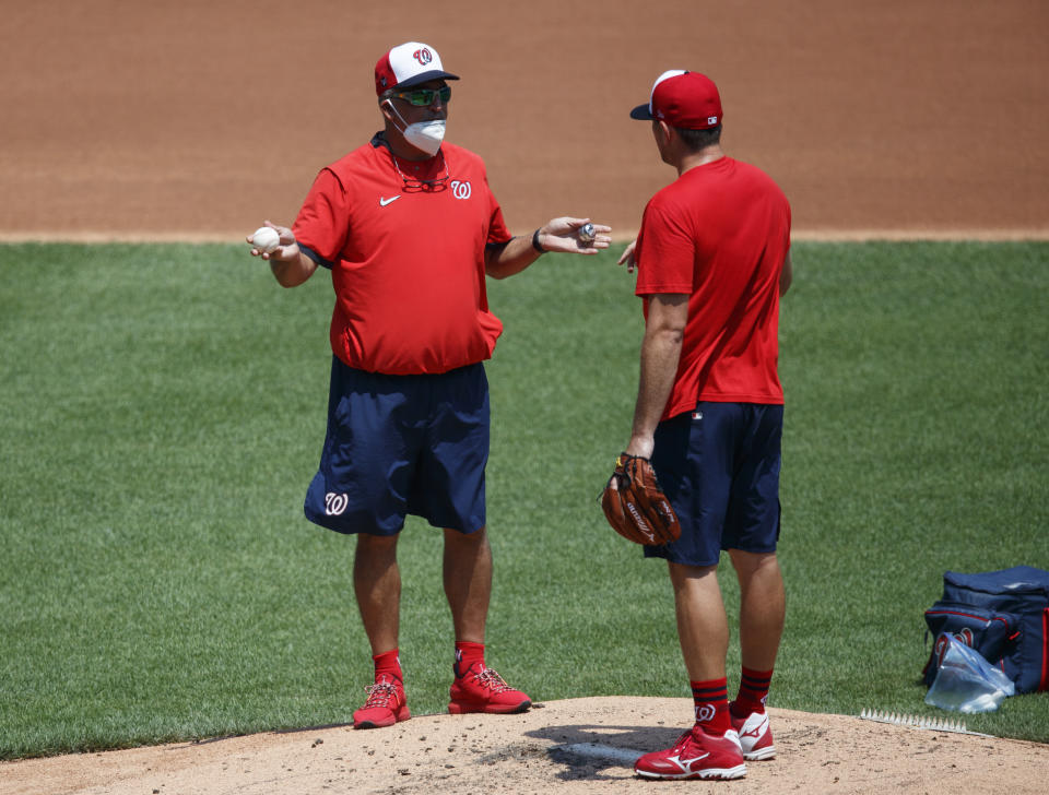 Washington Nationals' pitching coach Paul Menhart, left, talks with pitcher Daniel Hudson on the mound during a baseball training camp workout at Nationals Stadium, Sunday, July 5, 2020, in Washington. (AP Photo/Carolyn Kaster)