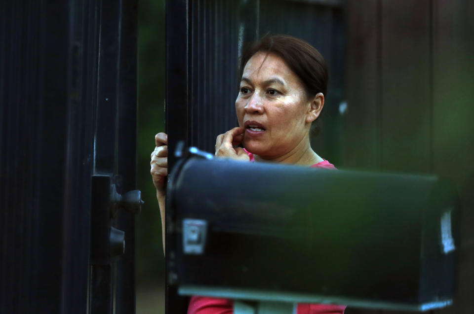 A woman watches as law enforcement officers surround a home where a gunman has taken refuge after shooting a Sacramento police officer, Wednesday, June 19, 2019, in Sacramento, Calif. (AP Photo/Rich Pedroncelli)