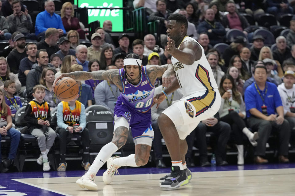 New Orleans Pelicans forward Zion Williamson (1) guards Utah Jazz guard Jordan Clarkson (00) during the first half of an NBA basketball game Thursday, Dec. 15, 2022, in Salt Lake City. (AP Photo/Rick Bowmer)