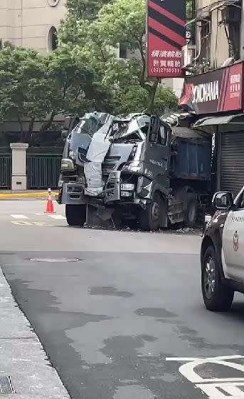 ▲砂石車直接撞上騎樓民宅，車頭全毀，所幸駕駛和遭到波及的騎士無大礙。（圖／翻攝畫面）