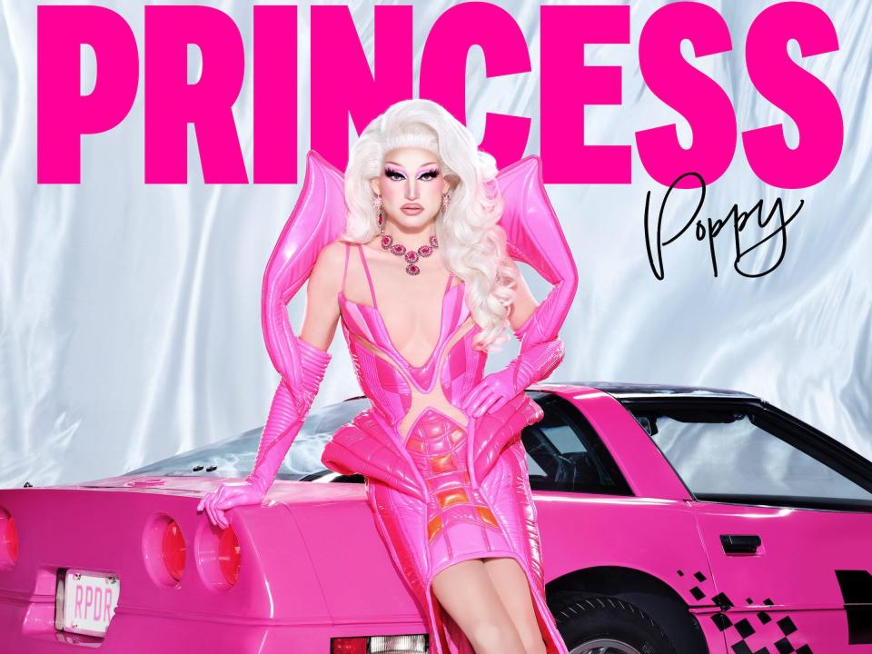 Princess Poppy poses in a pink gown, gloves, and heels against a pink sports car for her "RuPaul's Drag Race" season 15 headshot.