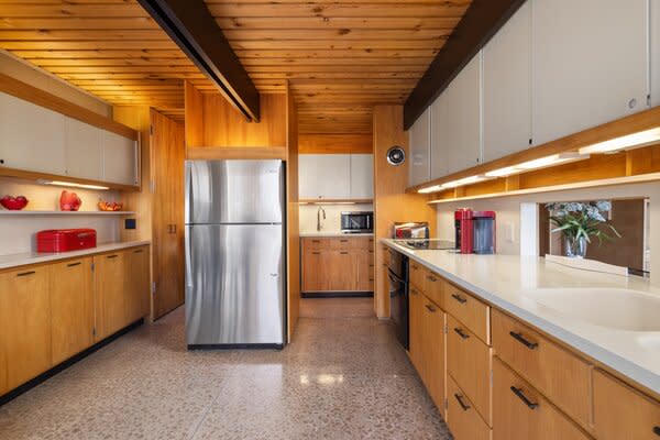 Wooden beams span across the kitchen, complete with ample counter space and cabinetry.
